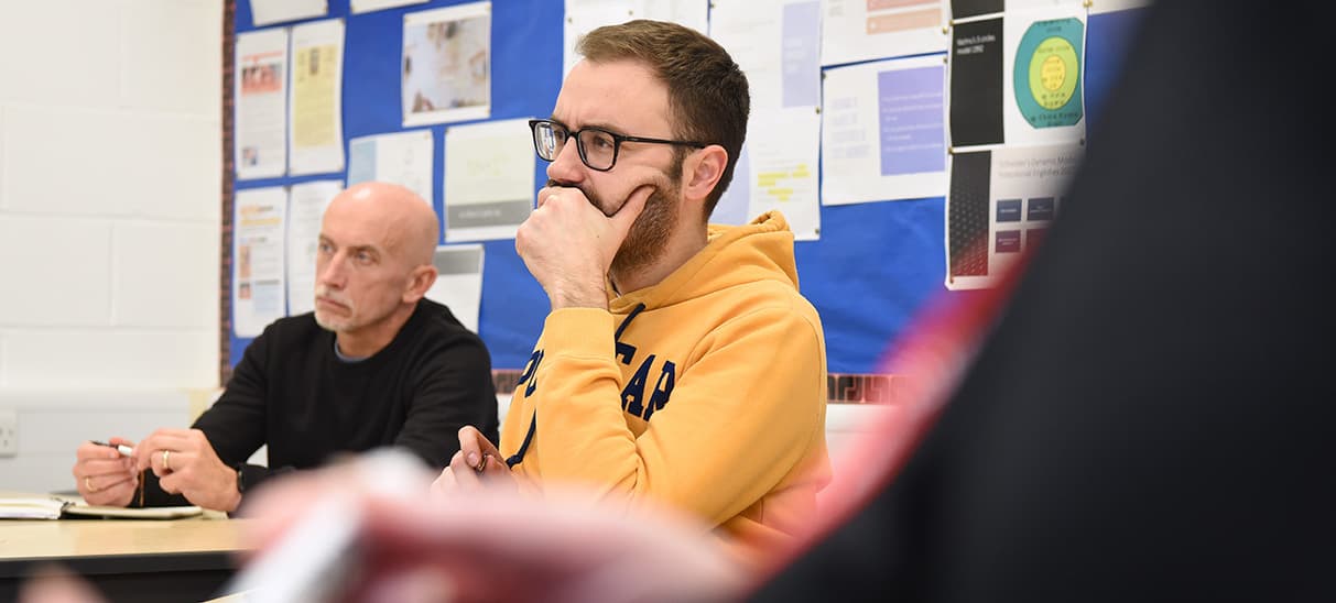 Adult Education students listening to tutor in a classroom