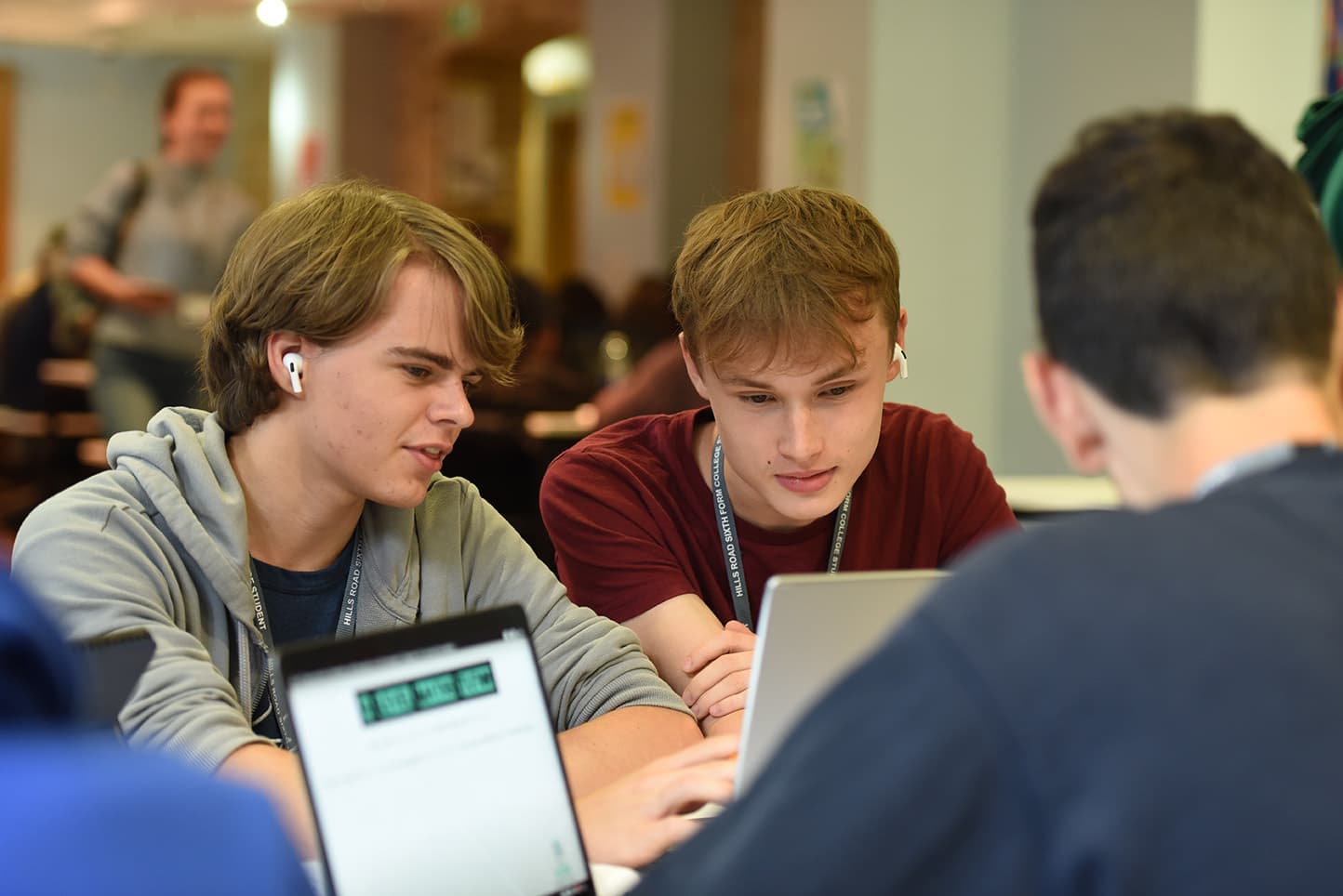 Three students sitting in a group with laptops